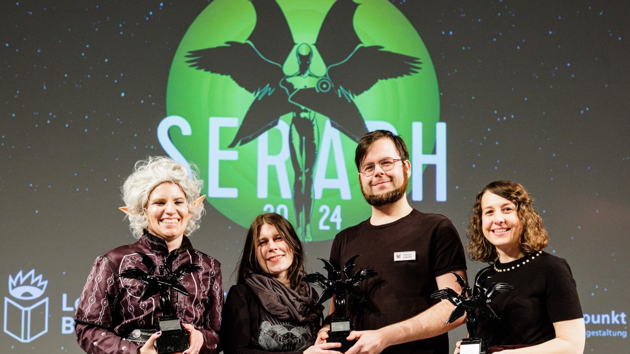 Die Preisträger:innen zeigen sich lächelnd mit ihren Preisen auf der Bühne bei der Verleihung vom Seraph 2024 auf der Leipziger Buchmesse