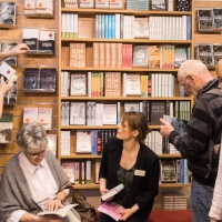 Ein Belletristik-Messestand auf der Leipziger Buchmesse mit vielen Leser:innen.