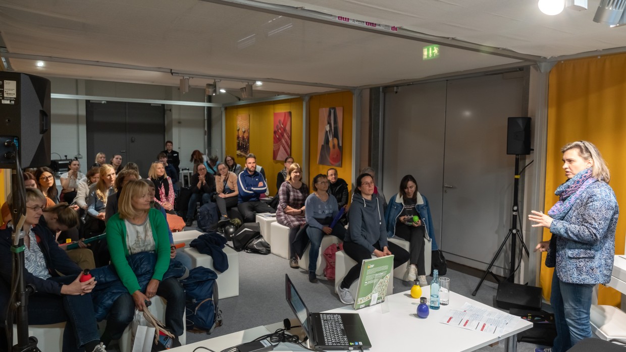 Foto von einem Vortrag im Musikzimmer auf der Leipziger Buchmesse 2023. Man sieht die Rednerin und das Publikum.