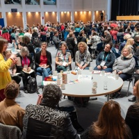 Tischgespräche im vollen Saal der Leipziger Autor:innenrunde 2024