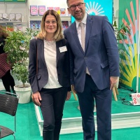 Margit Waslo posiert mit Staatsminister Martin Dulig am Messestand des Gastlandes 2025 Norwegen auf der Leipziger Buchmesse 2024