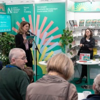 Margit Waslo spricht am Mikrofon bei der Eröffnung des Messestandes des Gastlandes 2025 Norwegen mit vielen Zuhörer:innen auf der Leipziger Buchmesse 2024 Margit Waslo spricht am Mikrofon bei der Eröffnung des Messestandes des Gastlandes 2025 Norwegen mit vielen Zuhörer:innen auf der Leipziger Buchmesse 2024