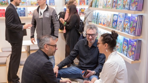Personen im Gespräch an einem Messestand während der Leipziger Buchmesse 2024