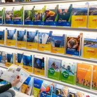 Lesender Besucher an einem Messestand mit großem Bücherregal auf der Leipziger Buchmesse 2024