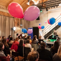 Leipzig liest Event mit Bühnentalk vor vollbesetztem Publikum in einem großen, mit Luftballons und Lichterketten geschmückten Raum während der Leipziger Buchmesse 2024