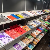 Langes Bücherregal mit verschiedenen Büchern aus dem Druckkunsbereich auf der Leipziger Buchmesse 2024