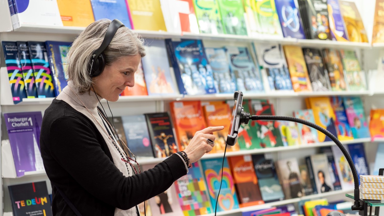 Besucherin mit Kopfhörern tippt auf ein Smartphone im Musikbereich während der Leipziger Buchmesse 2024 Besucherin mit Kopfhörern tippt auf ein Smartphone im Musikbereich während der Leipziger Buchmesse 2024