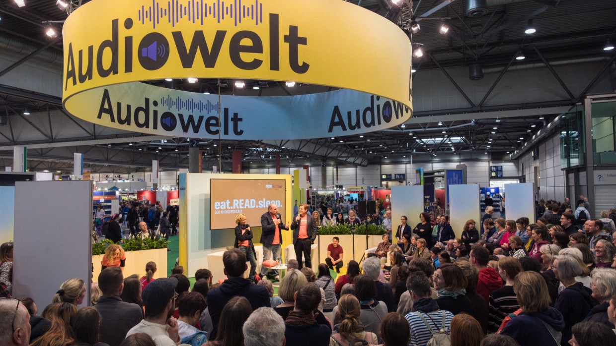 Bühnenveranstaltung des Podcasts "eat.read.sleep." mit mehreren Personen in der Audiowelt der Leipziger Buchmesse 2025 vor vollbesetztem Publikum.