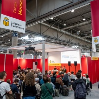 3 Personen sitzen bei einer Diskussionsrunde auf der Bühne vor Publikum im Forum Mensch & KI auf der Leipziger Buchmesse 2025