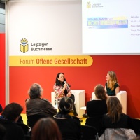 2 Personen sitzen bei einer Diskussionsrunde auf der Bühne vor Publikum im Forum Offene Gesellschaft auf der Leipziger Buchmesse 2025