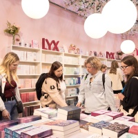 Besucher:innen stöbern durch die Bücher am LYX Stand 
