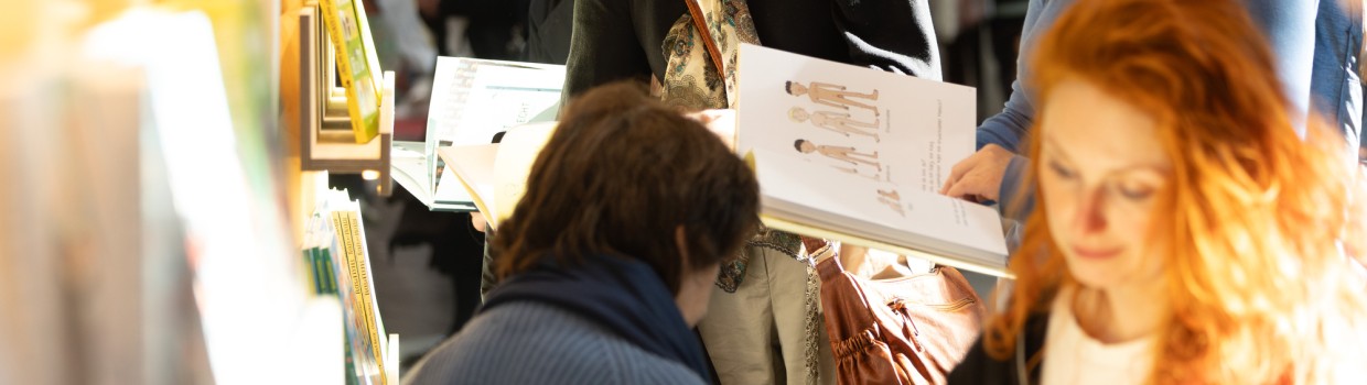 Impression von lesenden Besucher:innen an Bücherregalen auf der Leipziger Buchmesse 2025