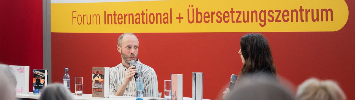 Bühnengespräch mit 2 Teilnehmer:innen auf der Bühne des Forum International + Übersetzungszentrum auf der Leipziger Buchmesse 2025