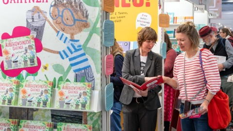 Zwei Frauen unterhalten sich über ein Kinderbuch auf der Leipziger Buchmesse 2025