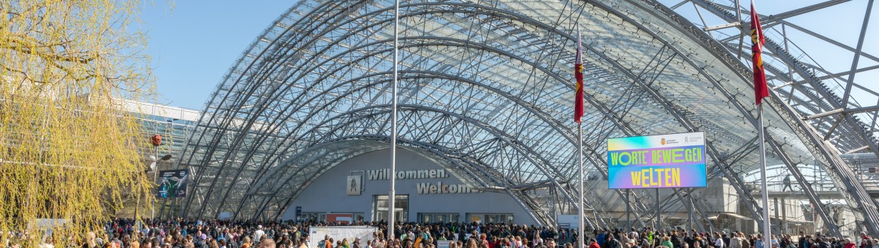 Impression von der Buchmesse 2025 mit vielen Besucher:innen vor dem Haupteingang der Glashalle