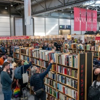 Leipziger Antiquariatsmesse auf der Leipziger Buchmesse 2025 mit Besucherinnen vor Bücherregalen
