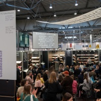 Der Buchkunst-Messebereich auf der Leipziger Buchmesse 2025 mit Besucherinnen vor Bücherregalen