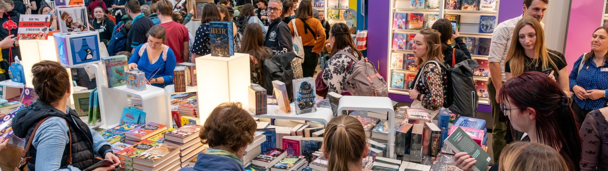 Impression von stöbernden Besucher:innen an Büchertischen auf der Leipziger Buchmesse 2025
