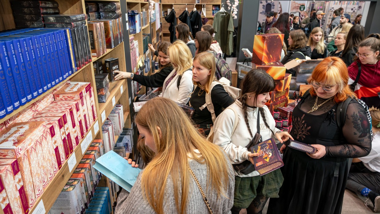 Impression von stöbernden Besucher:innen an Bücherregalen und Büchertischen auf der Leipziger Buchmesse 2025