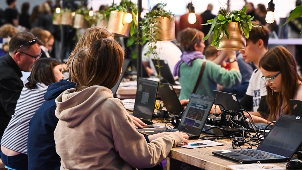 In der Hacker School im UVERSE auf der Leipziger Buchmesse 2025 sitzen Kinder an langen Tischen und arbeiten an Laptops In der Hacker School im UVERSE auf der Leipziger Buchmesse 2025 sitzen Kinder an langen Tischen und arbeiten an Laptops
