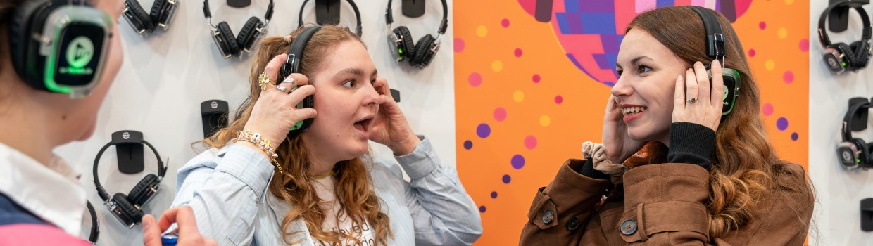 3 junge Besucherinnen nutzen Kopfhörer auf der Leipziger Buchmesse 2026