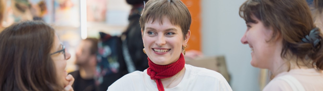 Ausstellerin mit Besucherinnen im Gespräch an einem Messestand auf der Leipziger Buchmesse 2026