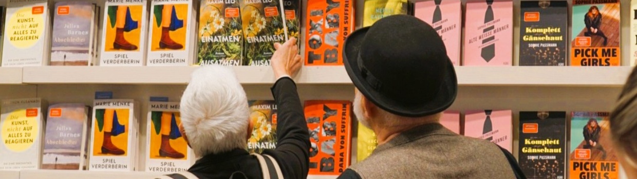 zwei Personen stehen vor einem vollen Bücherregal auf der Leipziger Buchmesse 2026