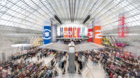 Blick in die volle Glashalle mit farbigen Bannern auf der Leipziger Buchmesse 2026