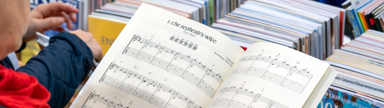 Person hält aufgeschlagenes Notenheft auf der Leipziger Buchmesse 2026