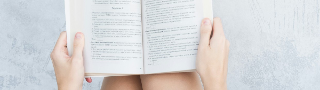 junge Frau hat ein aufgeschlagenes Buch auf ihren Beinen liegen