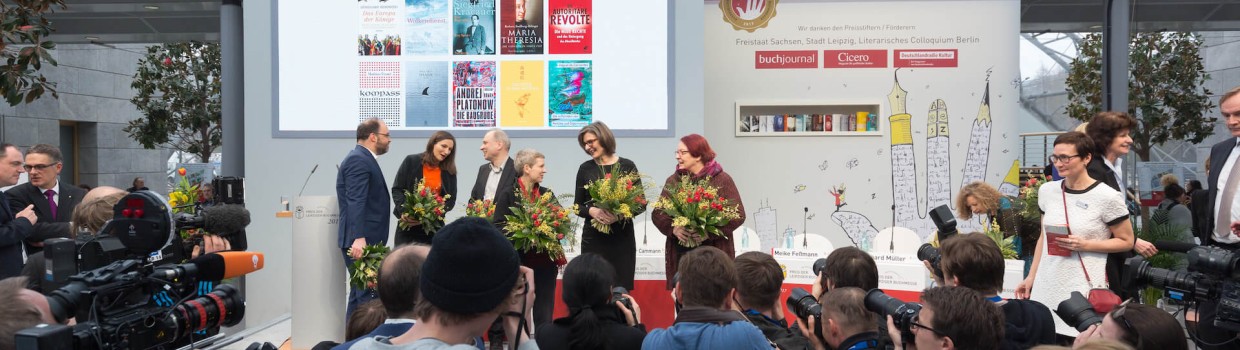Die Preisverleihung des Preis der Leipziger Buchmesse. Auf der Bühne stehen die vier Gewinner:innen und halten eine Blumenstrauß.