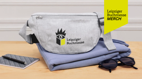 Leipziger Buchmesse Merch Shop: graue Bauchtasche mit LBM-Aufdruck auf einem Tisch