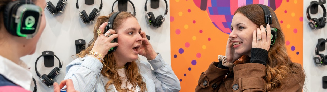 3 young visitors using headphones at Leipzig Book Fair 2026