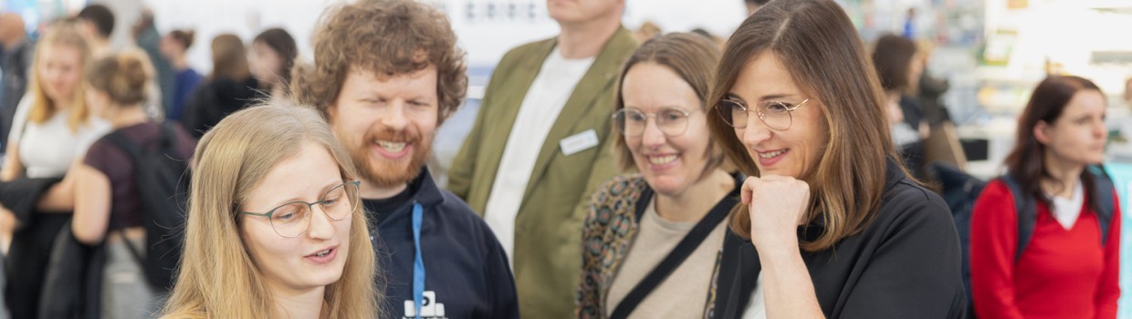 Exhibitors advise visitors at a booth counter during Leipzig Book Fair 2026