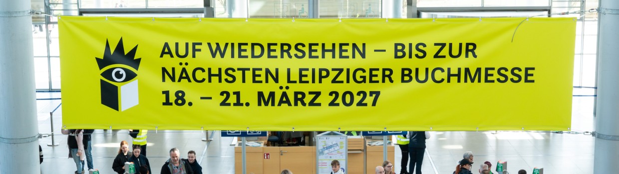 Yellow banner for Leipzig Book Fair 2027 above visitors in the entrance hall